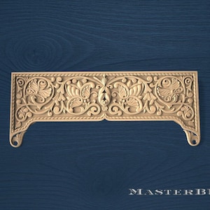Può includere: Un pannello decorativo in legno intagliato con un design floreale ornato. Il pannello è rettangolare con bordi curvi e presenta intagli dettagliati di foglie e fiori. Il testo "MASTERBUK" è in basso.