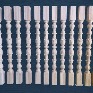 May include: A collection of unfinished wooden balusters, each with a square base, ornate carved details, and a rectangular top. The balusters are arranged in a row, showcasing variations in wood grain and color, perfect for home decor or woodworking projects.