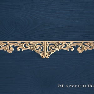 Puede incluir: Un elemento arquitectónico decorativo de madera tallada con un diseño ornamentado y simétrico. La pieza presenta patrones de hojas y espirales, y está sobre un fondo azul oscuro con vetas de madera. El texto "MASTERBUK" está en la parte inferior.