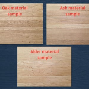three different types of wooden boards, each with a distinct label indicating the material used. The first board is labeled "Oak material sample", the second board is labeled "Ash material sample", and the third board is labeled "Alder material sample".