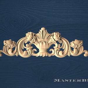 May include: A carved wooden decorative element with a symmetrical design. The piece features floral and scrollwork details, with a central vase-like shape flanked by stylized flowers. The background is a dark blue wood grain. The text "MASTERBUK" is at the bottom.
