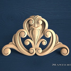 May include: A light-coloured wooden decorative carving featuring symmetrical scrollwork and acanthus leaf motifs. The piece has a central vertical element flanked by curved flourishes on both sides. The text MASTERBUK is visible in the bottom right corner.