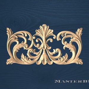 May include: A carved wooden decorative element with an ornate, symmetrical design. The piece features scrolling leaves and floral motifs in a light brown color, set against a dark blue background. The text "MASTERBUK" is visible at the bottom.