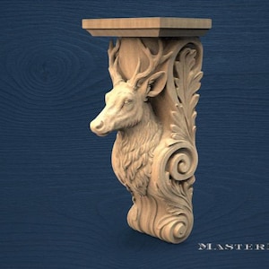 Puede incluir: Estante de pared de madera tallada con una cabeza de ciervo con cornamenta y detalles ornamentales de hojas y volutas. El estante tiene una parte superior rectangular y está hecho de madera de color claro. El diseño es intrincado y detallado, con un acabado natural.