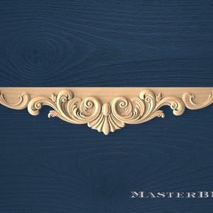 Può includere: Elemento architettonico decorativo in legno intagliato con un design simmetrico di foglie vorticose e motivi floreali. Il pezzo è marrone chiaro e montato su uno sfondo blu scuro. Il testo "MASTERBUK" è in basso.