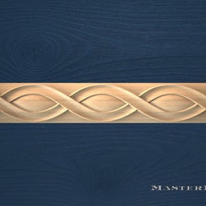 May include: A carved wooden decorative trim piece with an interwoven design. The trim is light brown and features a repeating pattern of curved, eye-shaped elements. The background is a dark blue wood grain.