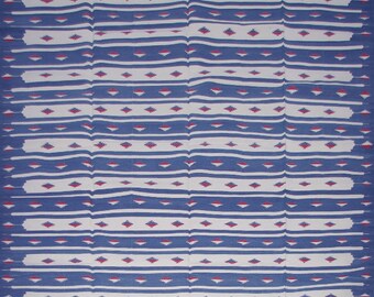 Puede incluir: Una manta tejida a rayas azules y blancas con un patrón de diamantes. La manta tiene un borde de flecos.