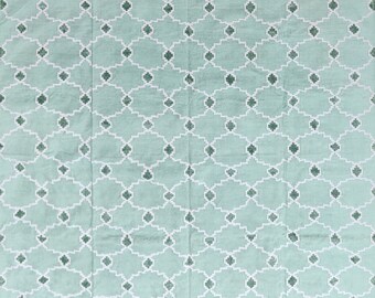 May include: A light blue rug with a white geometric pattern. The pattern is made up of small squares and diamonds.