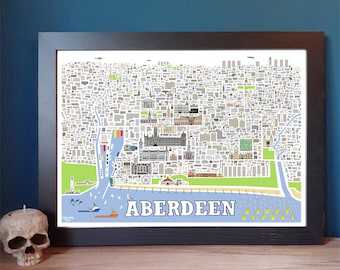 May include: A framed map of Aberdeen, Scotland, with a detailed illustration of the city's streets, buildings, and landmarks. The map is printed in a variety of colors and includes a blue and green waterfront with a lighthouse, a ferry, and a Ferris wheel.