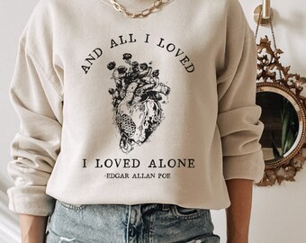 May include: A beige sweatshirt with a black graphic of a heart with flowers and the text "And all I loved I loved alone - Edgar Allan Poe".