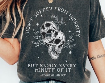 May include: A dark grey t-shirt with a graphic of two skulls with floral accents and the text "I don't suffer from insanity but enjoy every minute of it ~Edgar Allan Poe".