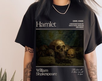 May include: Black t-shirt with a graphic of skulls and bones, text reads "Hamlet" and "William Shakespeare", and "Elsinore, Denmark A timeless tragedy delving into themes of revenge, madness and moral ambiguity They above all to these are self be true"