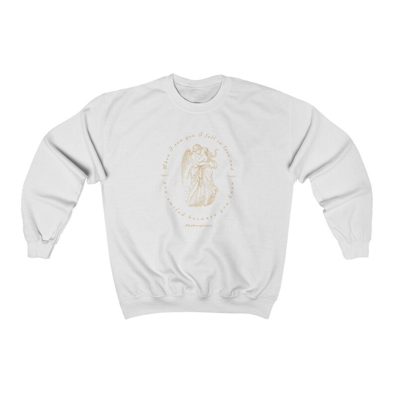 May include: White sweatshirt with a gold graphic of two angels embracing. The graphic is surrounded by a circle with the text "When I saw you I fell in love and I knew I was smiled because you are my smile" and "Shakespeare".