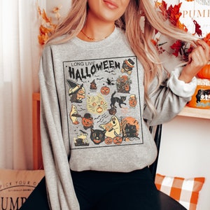 May include: A gray sweatshirt with a vintage-style Halloween graphic. The graphic features a witch, ghosts, cats, pumpkins, and the text "Long Live Halloween".