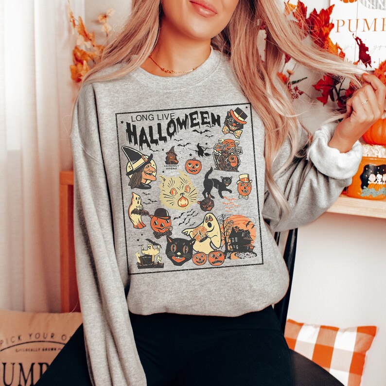 May include: A gray sweatshirt with a vintage-style Halloween graphic. The graphic features a witch, ghosts, cats, pumpkins, and the text "Long Live Halloween".