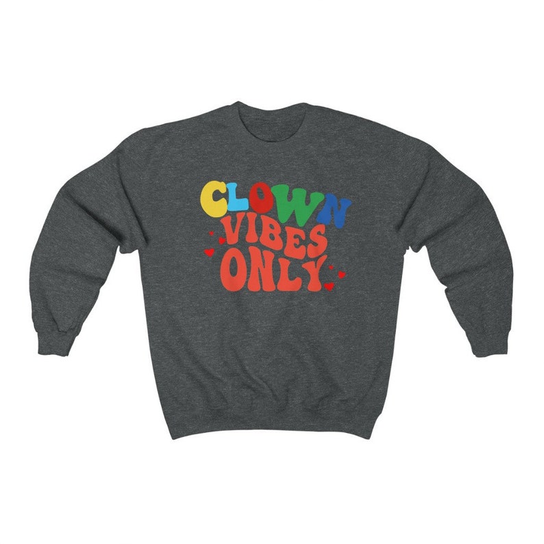 Może przedstawiać: Szara bluza z kapturem z napisem "CLOWN VIBES ONLY" w kolorowych literach. Litery są w stylu retro.