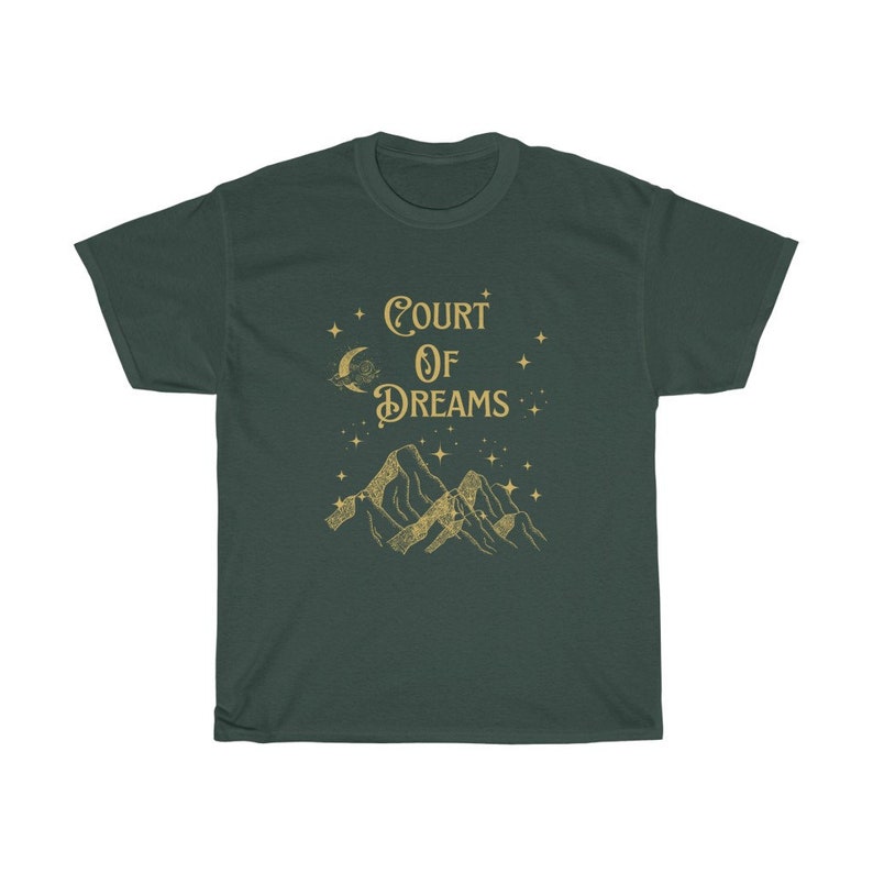 May include: A dark green t-shirt featuring a gold graphic of mountains, a crescent moon, and stars. The text "COURT OF DREAMS" is printed in gold on the shirt.