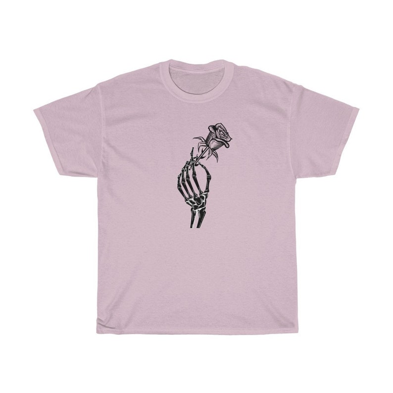 K&ouml;nnte beinhalten: Ein hellrosa T-Shirt mit einem schwarz-wei&szlig;en Motiv einer Skeletthand, die eine Rose h&auml;lt.