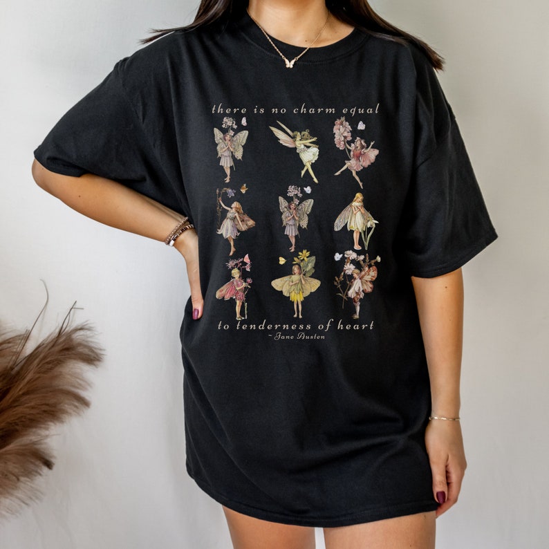 May include: Black oversized t-shirt with a graphic print of fairies and flowers. The text "there is no charm equal to tenderness of heart - Jane Austen" is printed on the shirt.