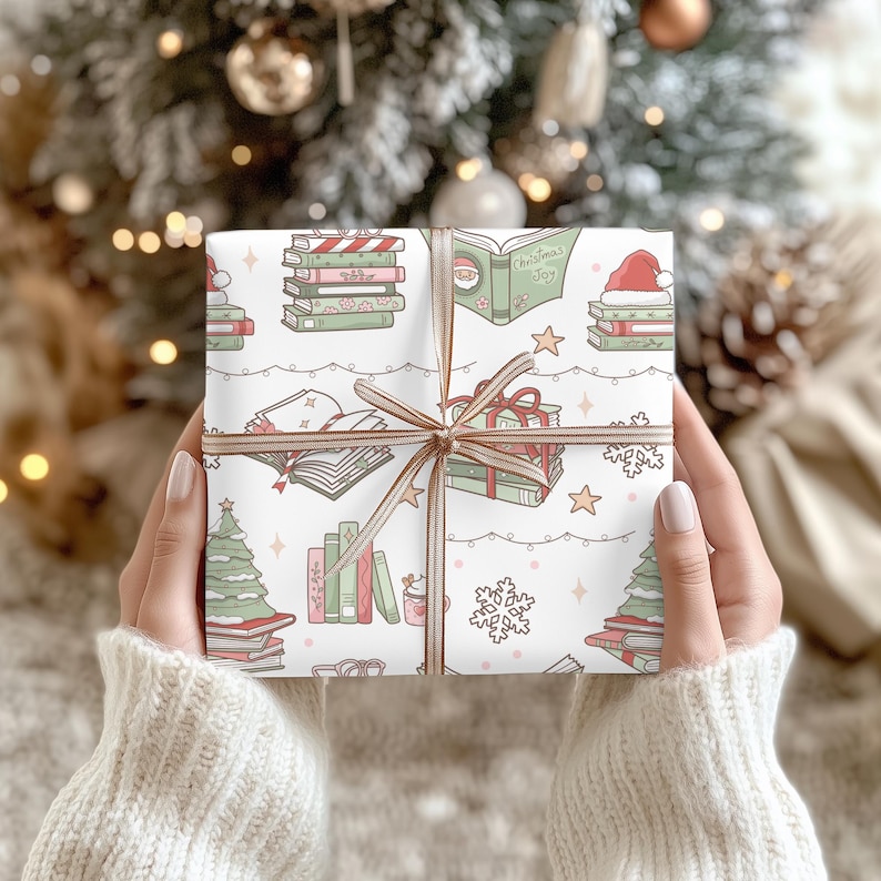 May include: A wrapped gift with a festive Christmas-themed pattern. The wrapping paper features illustrations of books, Christmas trees, Santa hats, and snowflakes in red, green, and pink on a white background. The gift is tied with a brown ribbon.