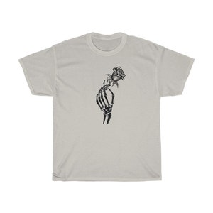 K&ouml;nnte beinhalten: Ein wei&szlig;es T-Shirt mit einem schwarz-wei&szlig;en Motiv einer Skeletthand, die eine Rose h&auml;lt.