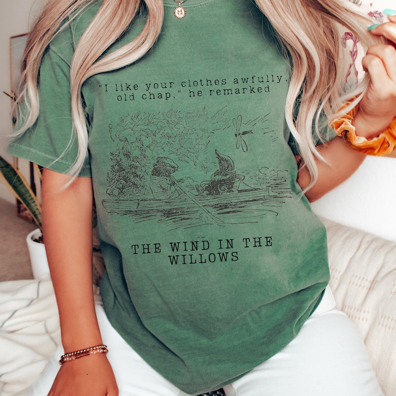 May include: Green t-shirt with a vintage illustration of two animals in a boat and the text "I like your clothes awfully, old chap," he remarked THE WIND IN THE WILLOWS".