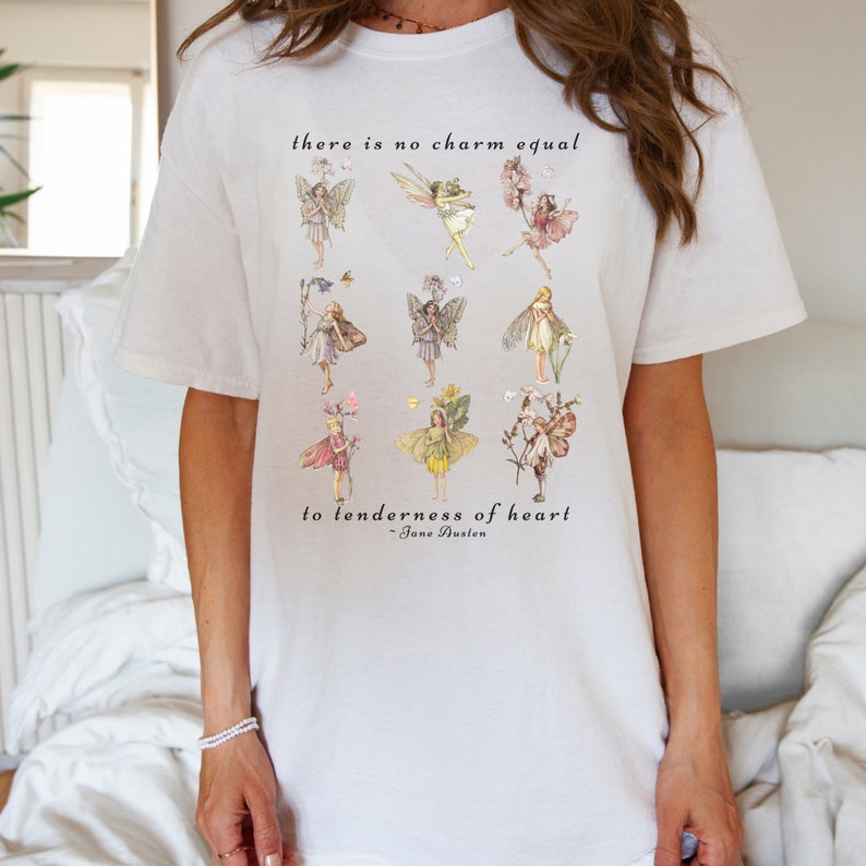 May include: White t-shirt with a quote about tenderness of heart, featuring a design of fairies and flowers. The quote reads "there is no charm equal to tenderness of heart - Jane Austen".