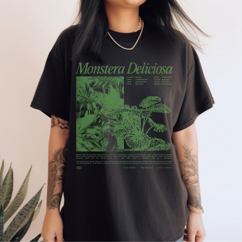 May include: Black t-shirt with a green print of a Monstera Deliciosa plant. The print includes the scientific classification of the plant: Kingdom: Plantae, Order: Alismatales, Class:  Liliopsida, Family: Araceae, Genus: Monstera, Species: Deliciosa.