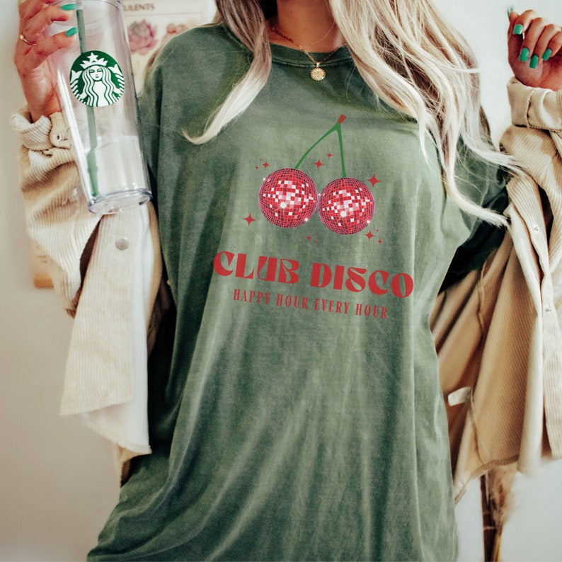 May include: Green t-shirt with a red cherry graphic and the text "Club Disco Happy Hour Every Hour".