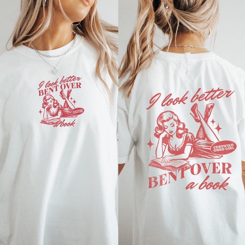 K&ouml;nnte beinhalten: Wei&szlig;es T-Shirt mit roter Grafik auf der Vorder- und R&uuml;ckseite. Die Grafik zeigt eine Vintage-Illustration einer Frau, die ein Buch liest, mit dem Text "I look better bent over a book" und "Certified Good Girl".
