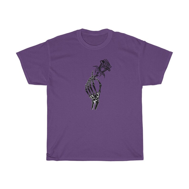 K&ouml;nnte beinhalten: Ein lila T-Shirt mit einer schwarz-wei&szlig;en Grafik einer Skeletthand, die eine Rose h&auml;lt.
