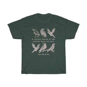 以下が含まれることがあります： 6羽の黒いカラスと「A stately Raven of the saintly days of yore - Edgar Allan Poe 1845」というテキストが白でプリントされた濃い緑色のTシャツです。