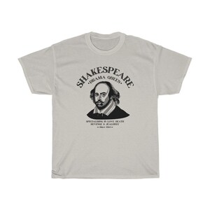 May include: A light grey t-shirt with a black graphic of William Shakespeare. The graphic includes the text "Shakespeare, Drama Queen, Specialising in Love, Death, Revenge & Jealousy - Since 1564 - "