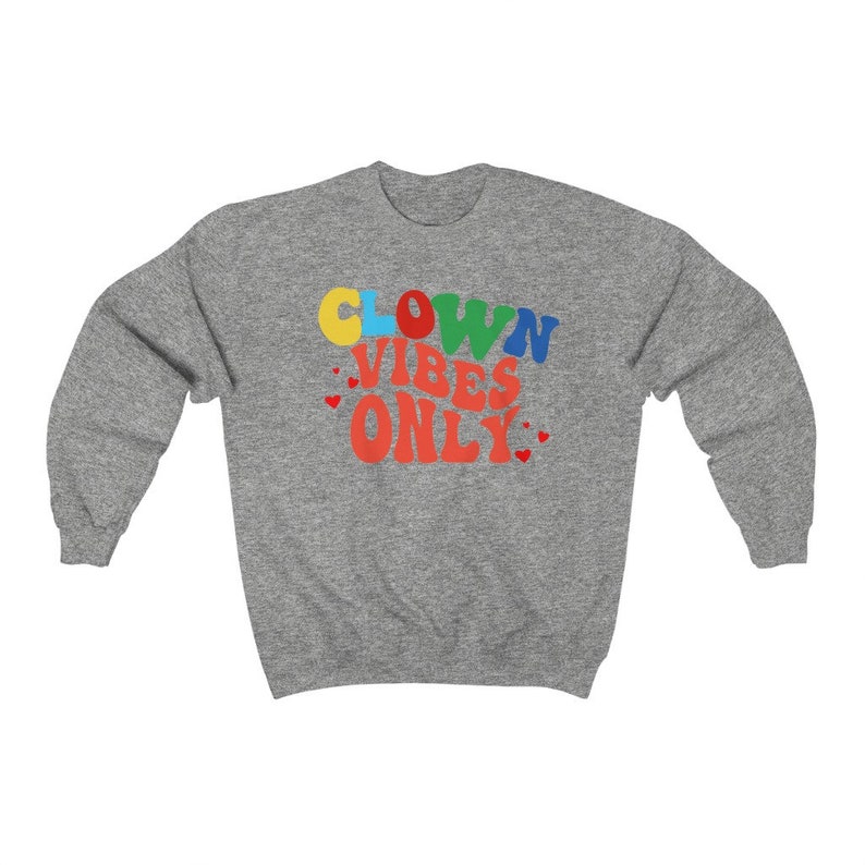 Może przedstawiać: Szara bluza z napisem "CLOWN VIBES ONLY" w kolorowych literach z czerwonymi sercami wok&oacute;ł tekstu.
