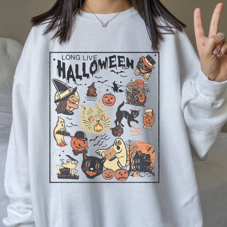 May include: White sweatshirt with a vintage Halloween graphic print featuring a black cat, ghosts, pumpkins, and the text "Long Live Halloween".