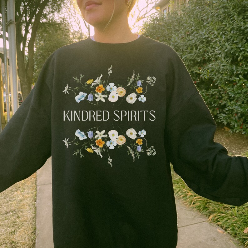May include: Black sweatshirt with a floral design and the text "KINDRED SPIRITS" in white.