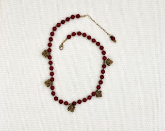 Persian looking brass charms and deep red ceramic beaded necklace with brass spacer beads.