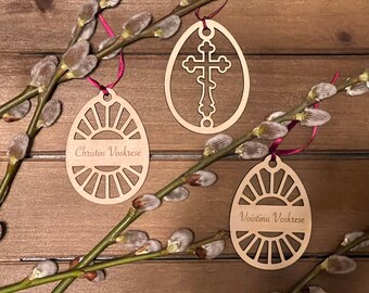 May include: Three wooden Easter egg ornaments with different designs. One has a cross, one says "Christos Voskrese", and one says "Voistinu Voskrese".