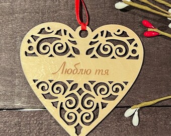 May include: A wooden heart-shaped ornament with a decorative cutout design and the text "Люблю тя" in Cyrillic script.