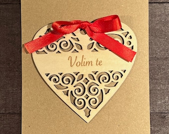 May include: A wooden heart with a red ribbon and the text "Volim te" on a brown card.