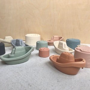 May include: A set of 10 colourful bath toys in the shape of boats and cylinders. The toys are made of a soft, textured material and are perfect for bath time fun.