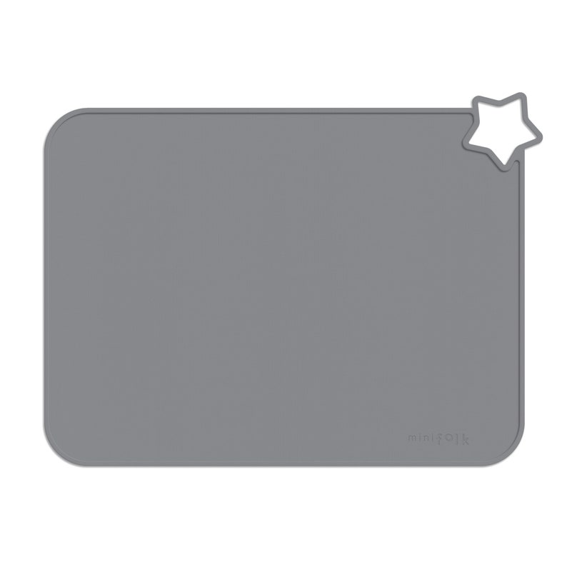 May include: Grey silicone placemat with a star-shaped cutout in the top right corner. The placemat has the word "minifolk" printed in white in the bottom right corner.