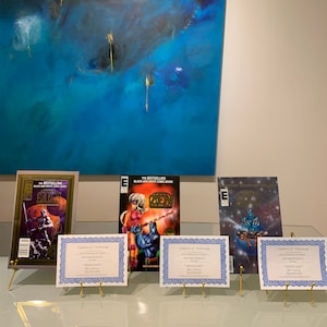 May include: Four comic books with certificates of authenticity on display stands. The comic books are all black and white and feature a character called "Zen". The comic books are titled "The Bestselling Black and White Comic Book".
