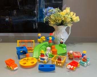 Pode incluir: Uma coleção de brinquedos infantis vintage, incluindo um conjunto de parque infantil com escorrega, baloiços e carrossel. O conjunto apresenta cores vivas como laranja, amarelo, azul e verde. Um vaso branco com flores amarelas está no fundo.