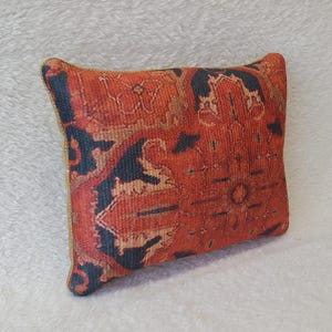 May include: A red, black, and gold patterned throw pillow with a geometric design.