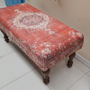 Peut inclure: Un banc rouge et crème à motifs avec des pieds en bois. Le banc a un design traditionnel et est parfait pour ajouter une touche d'élégance à n'importe quelle pièce.