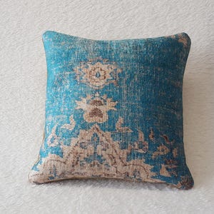 May include: A blue and cream patterned throw pillow with a vintage design.