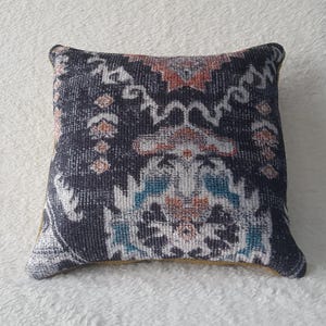 May include: A decorative throw pillow with a blue, white and orange geometric pattern.