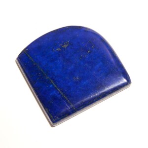 Può includere: Una pietra preziosa di lapislazzuli di colore blu scuro, di forma irregolare, con macchie dorate. La pietra è lucidata e ha una superficie liscia.