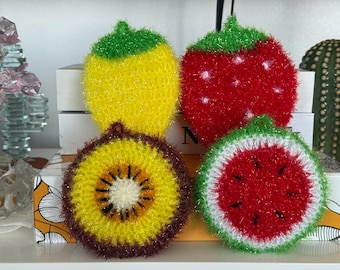 Puede incluir: Cuatro estropajos redondos y texturizados con forma de fruta. La fila superior incluye un limón amarillo y una fresa roja con puntos blancos. La fila inferior presenta una rodaja de kiwi amarilla y marrón y una rodaja de sandía roja.